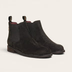 Botín chelsea negro de cuero nobuk de OLKI, diseño urbano sin cordones con elásticos laterales y tiradores.