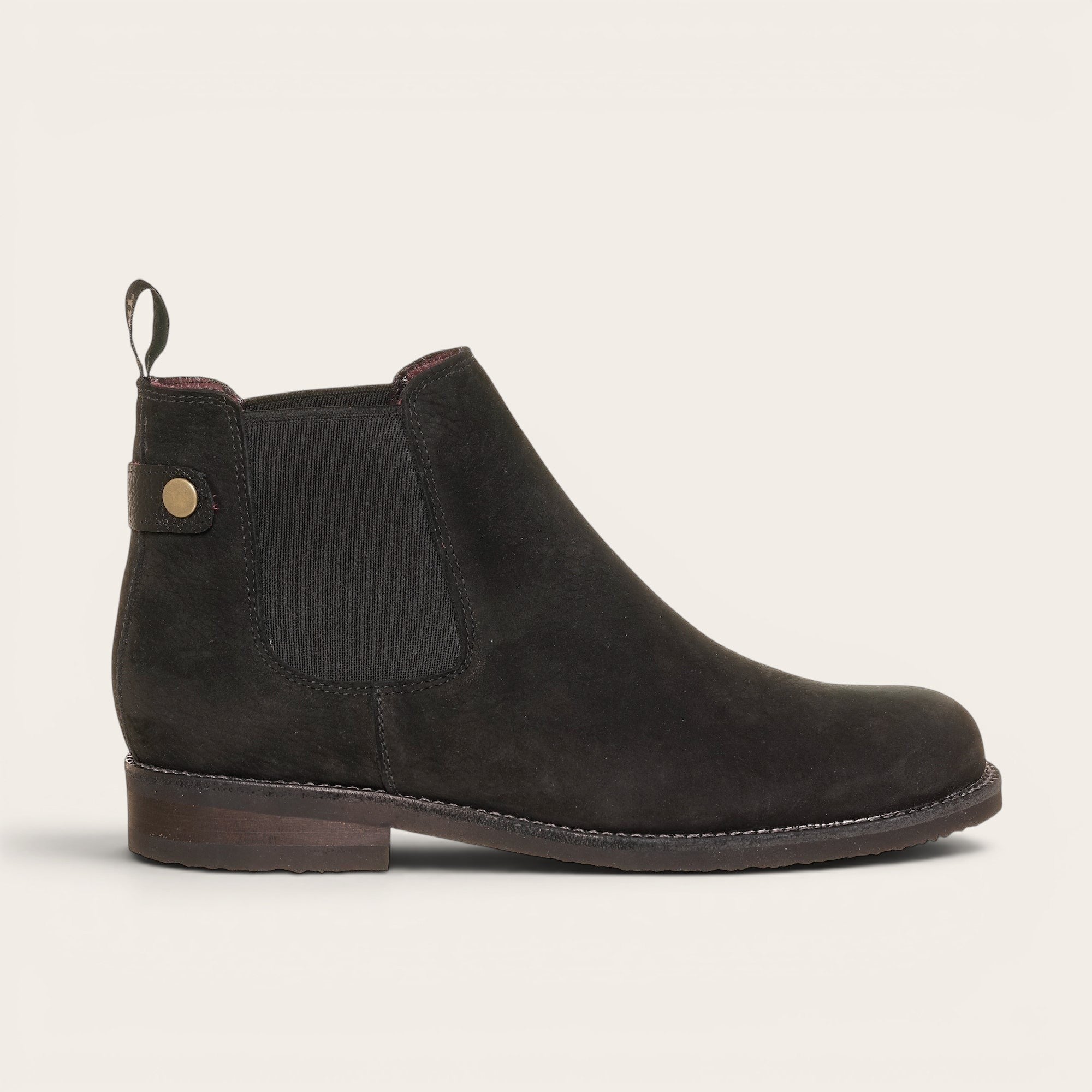 Botín chelsea negro de cuero nobuk de OLKI, diseño urbano sin cordones con elásticos laterales y tiradores.