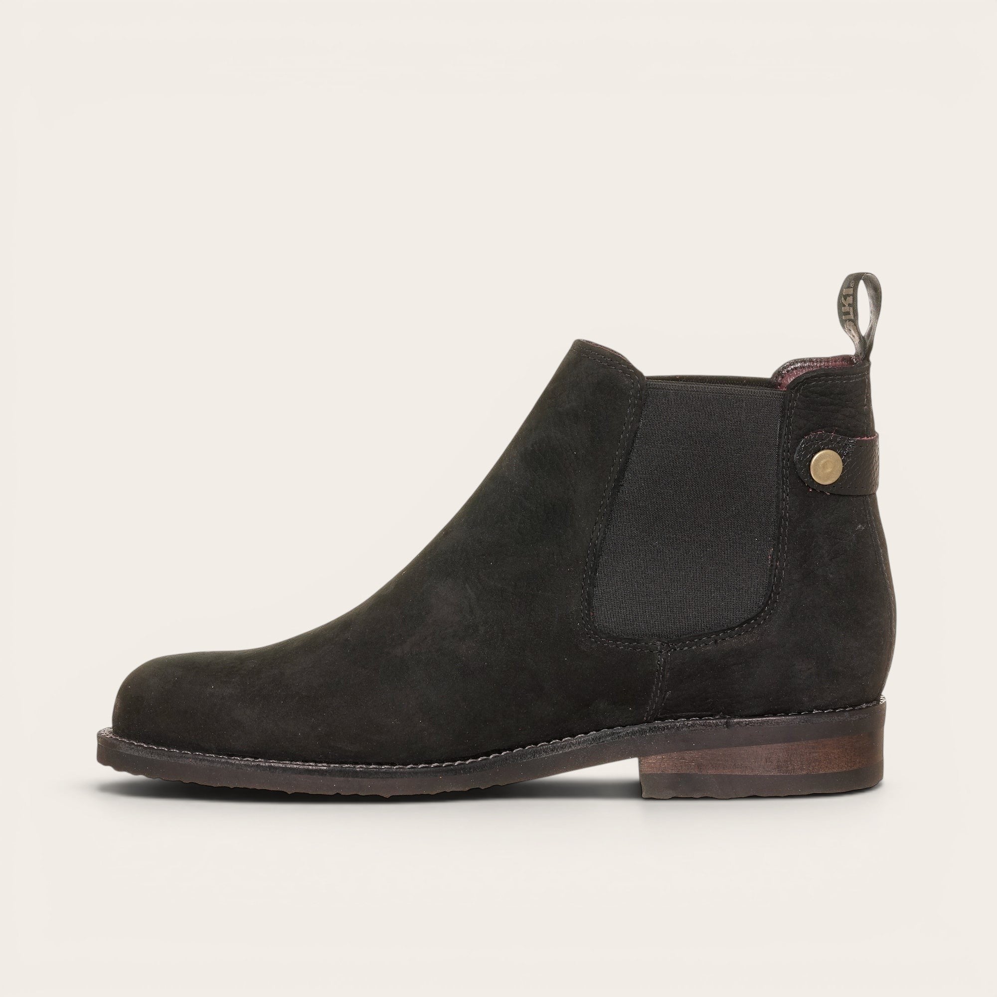 Botín chelsea negro de cuero nobuk de OLKI, diseño urbano sin cordones con elásticos laterales y tiradores.