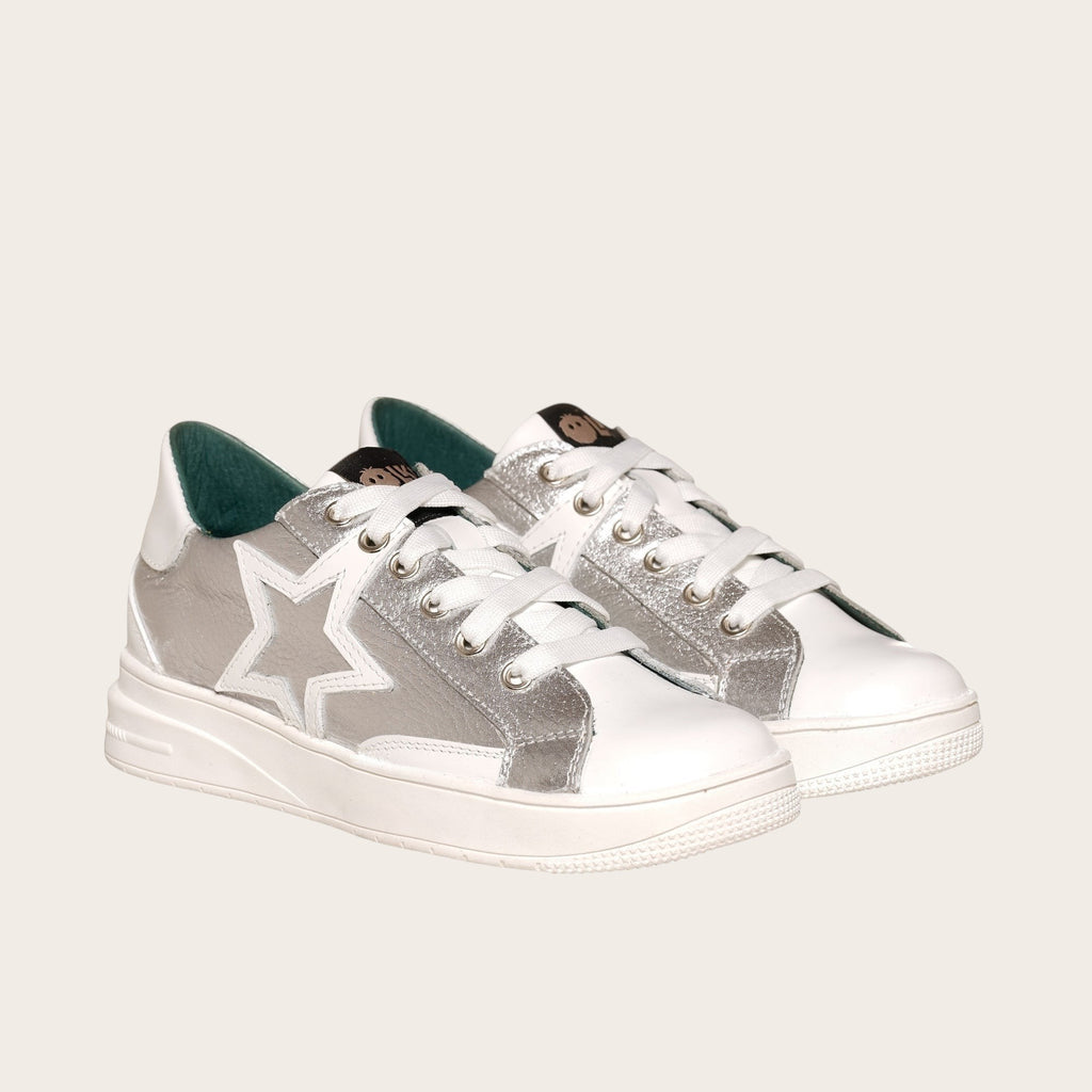 Zapatilla OLKI Loica blanca con detalle de estrella plateada, cordones blancos y planta de caucho.