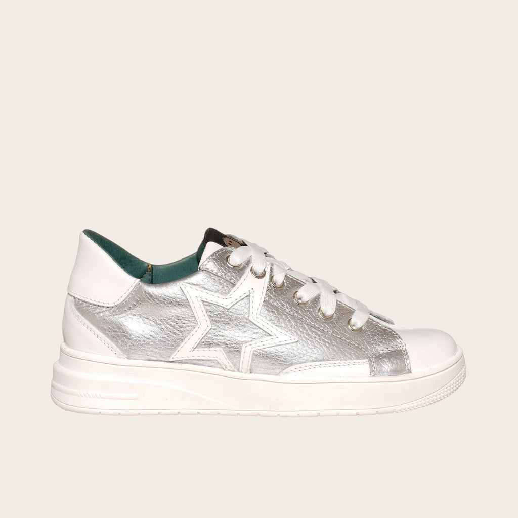 Zapatilla OLKI Loica blanca con detalle de estrella plateada, cordones blancos y planta de caucho.