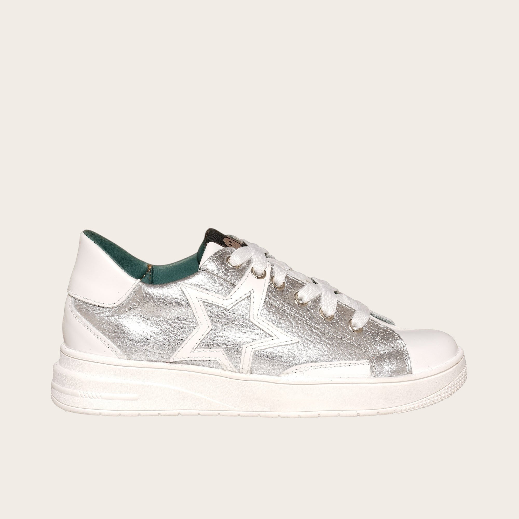 Zapatilla OLKI Loica blanca con detalle de estrella plateada, cordones blancos y planta de caucho.