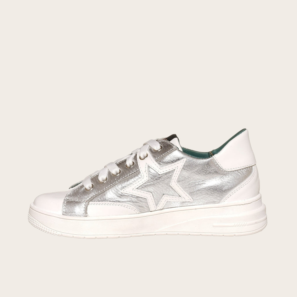 Zapatilla OLKI Loica blanca con detalle de estrella plateada, cordones blancos y planta de caucho.