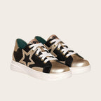 Zapatilla OLKI Loica negra y dorada con detalle de estrella, cordones blancos y planta de caucho.
