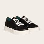 Zapatilla OLKI Real negra de piel con cordones blancos y planta de plataforma blanca. Diseño acolchado.