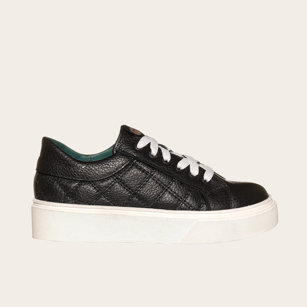 Zapatilla OLKI Real negra acolchada de piel con cordones blancos y planta de plataforma blanca.