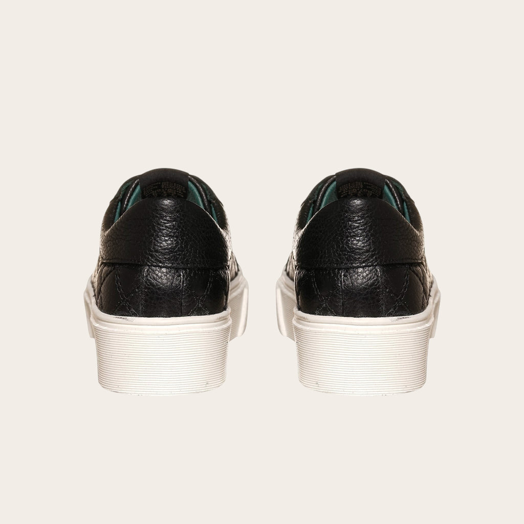 Zapatilla OLKI Real negra de cuero con acolchado lateral y planta blanca de plataforma.