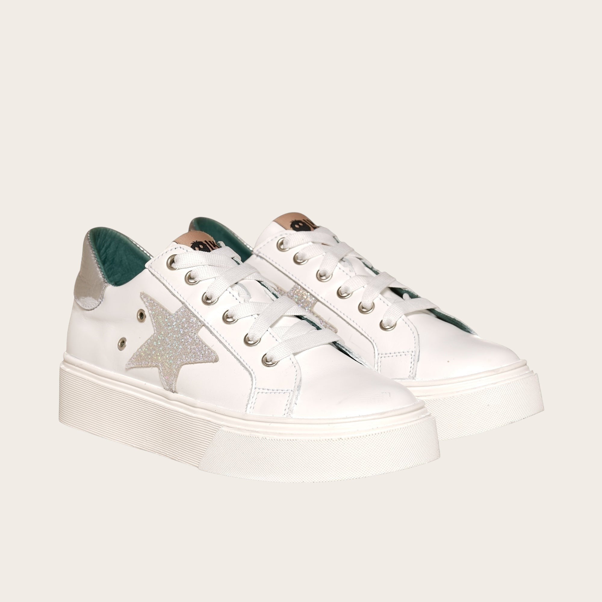 Zapatilla OLKI Tricahue blanca con detalle de estrella plateada brillante y suela de plataforma blanca.