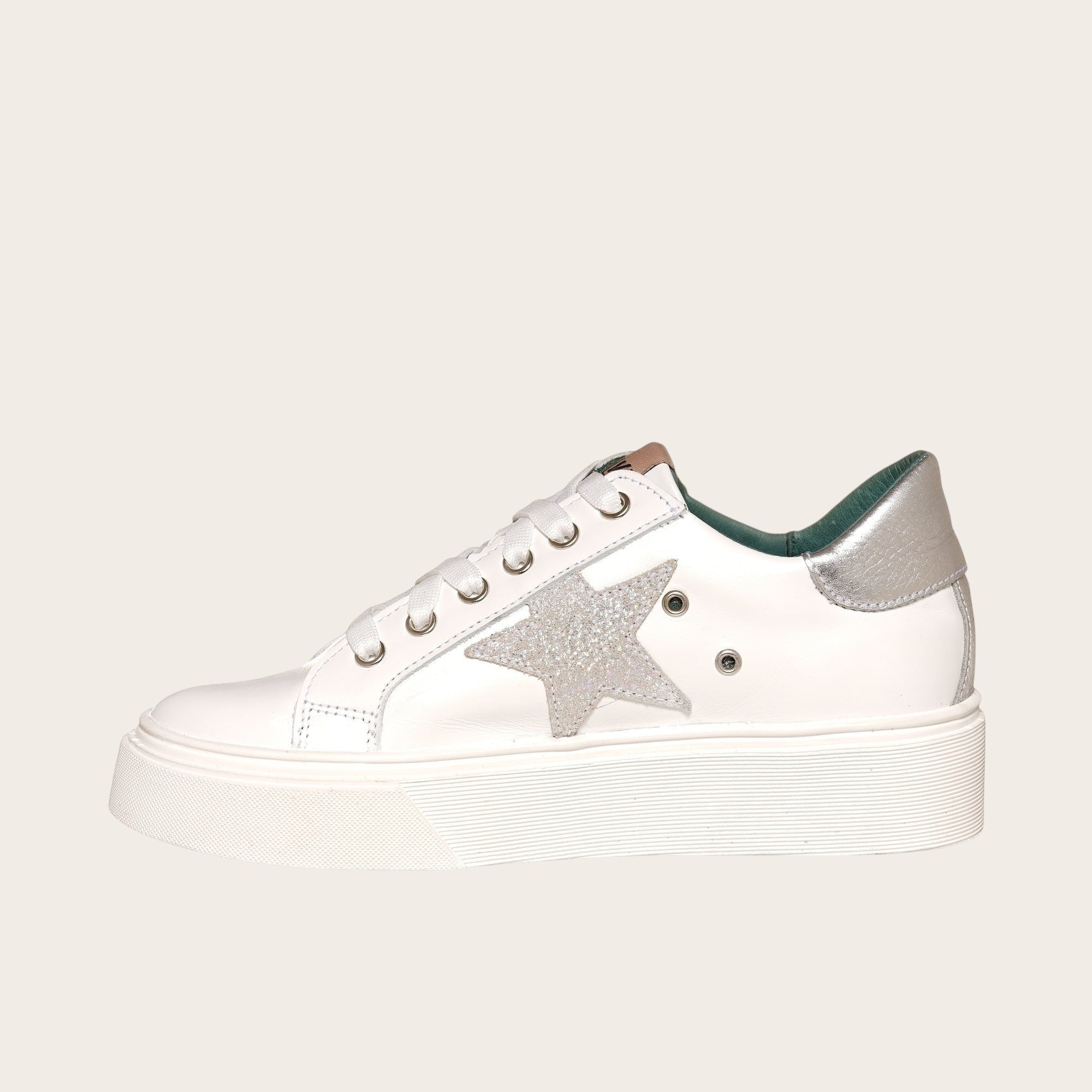 Zapatilla OLKI Tricahue blanca con estrella plateada brillante, cordones blancos y planta de plataforma blanca.