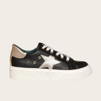Zapatilla OLKI Tricahue negra con detalle de estrella dorada, cordones blancos y planta de plataforma blanca.