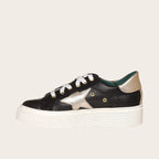 Zapatilla OLKI Tricahue negra con detalle de estrella dorada, cordones blancos y planta de plataforma blanca.