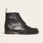 Botín de cuero negro OLKI con cordones, suela negra y detalles brogue. Diseño urbano y elegante.