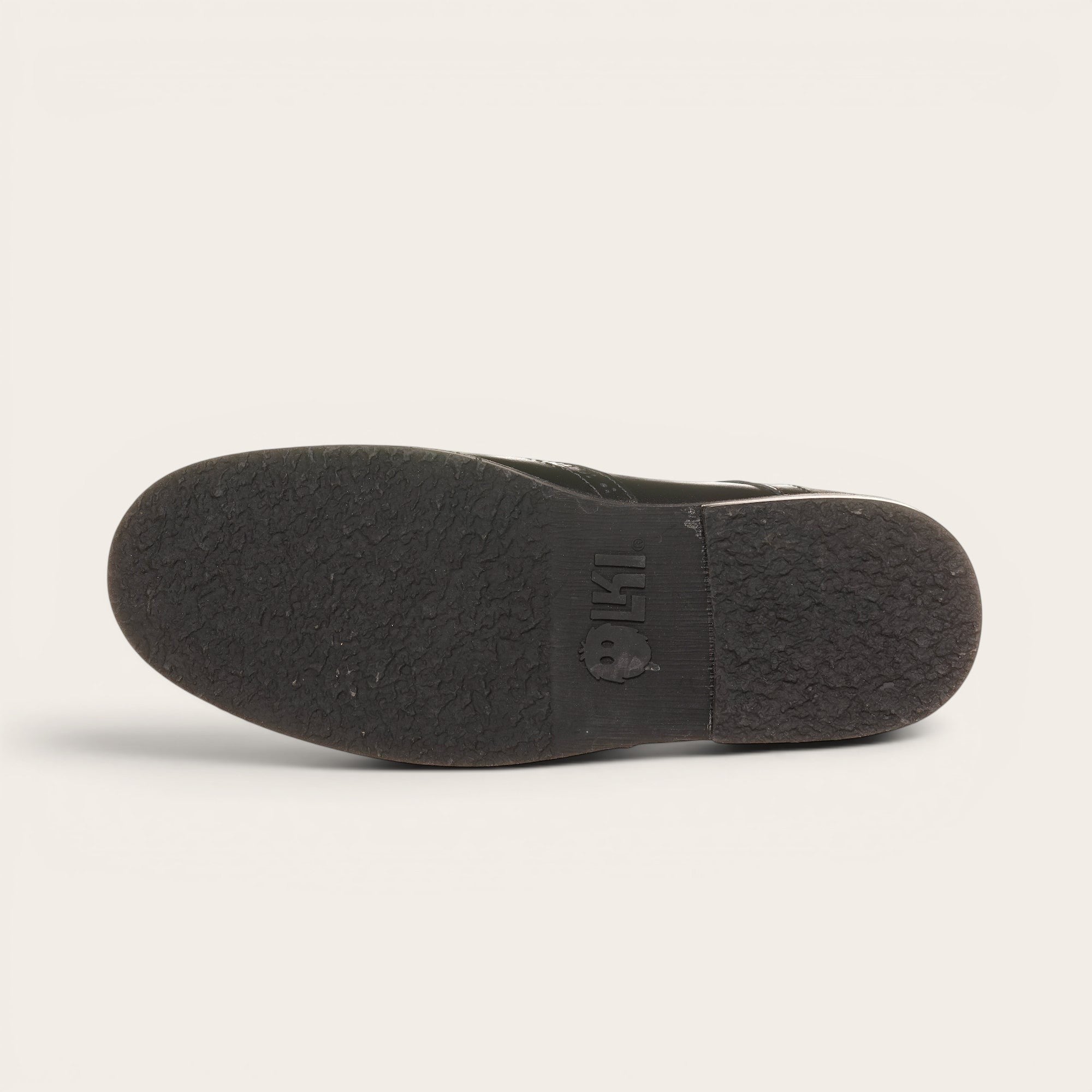 Botín de cuero negro OLKI con cordones, suela negra y detalles brogue. Diseño urbano y elegante.