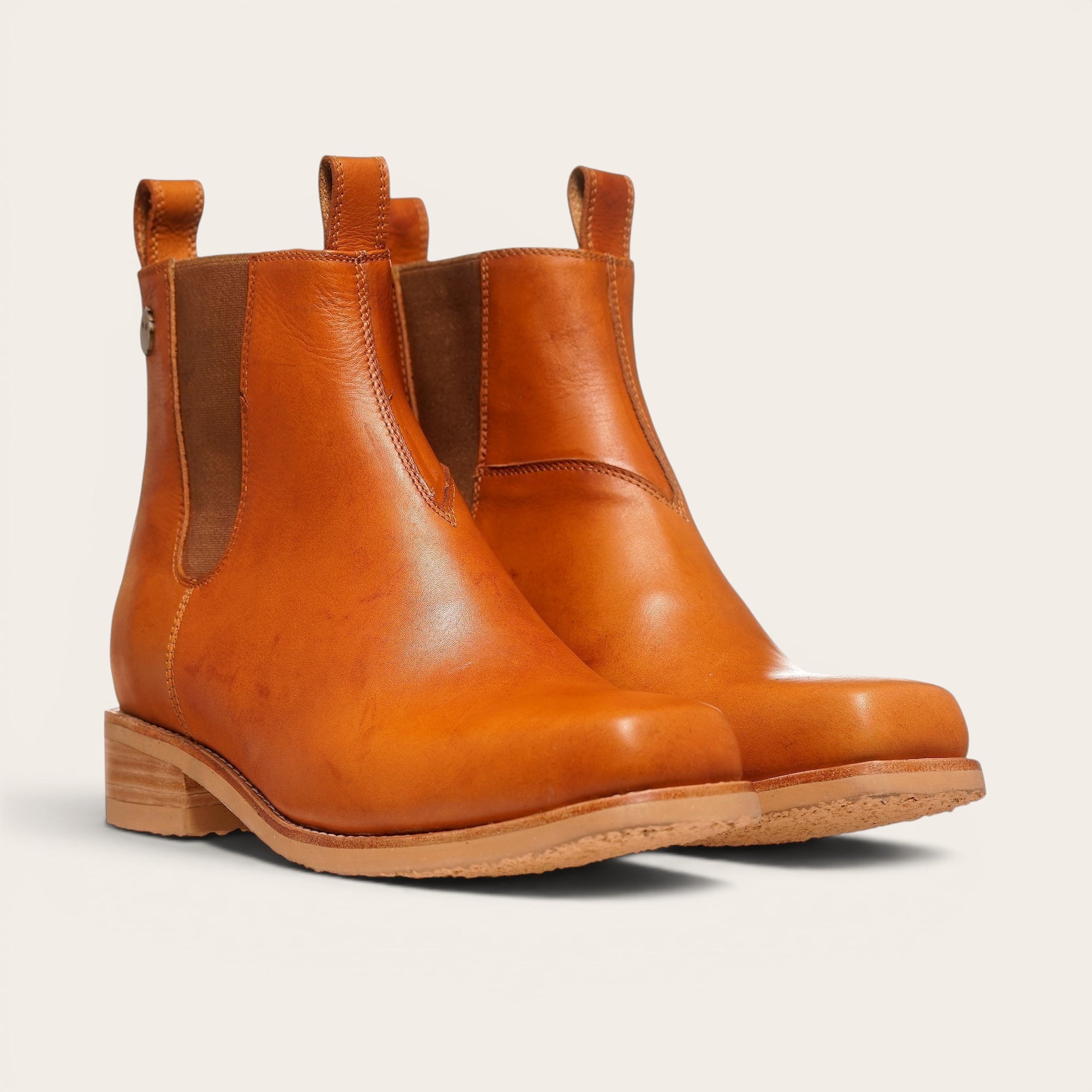 Botas OLKI Llanquihue de cuero liso color curry con paneles elásticos laterales, con suela de cuero y planta de caucho.