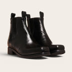 Botines negros de cuero liso OLKI Llanquihue con paneles elásticos laterales y caña alta.