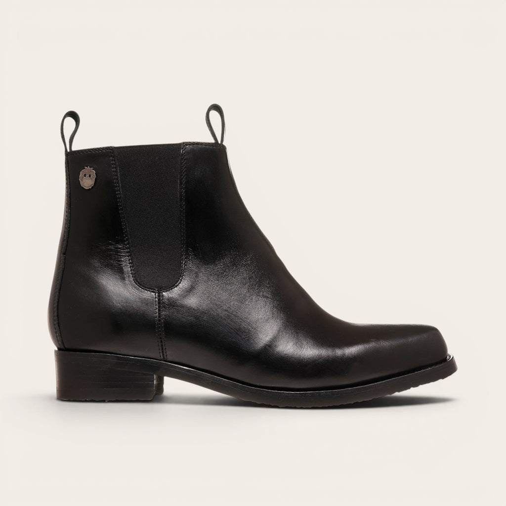 Botines negros de cuero liso OLKI Llanquihue con paneles elásticos laterales y caña alta.