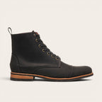 Botín Osorno Negro Planta Negra de cuero para hombre de OLKI. Diseño clásico con ojales metálicos, tirante trasero y suela de cuero y caucho.