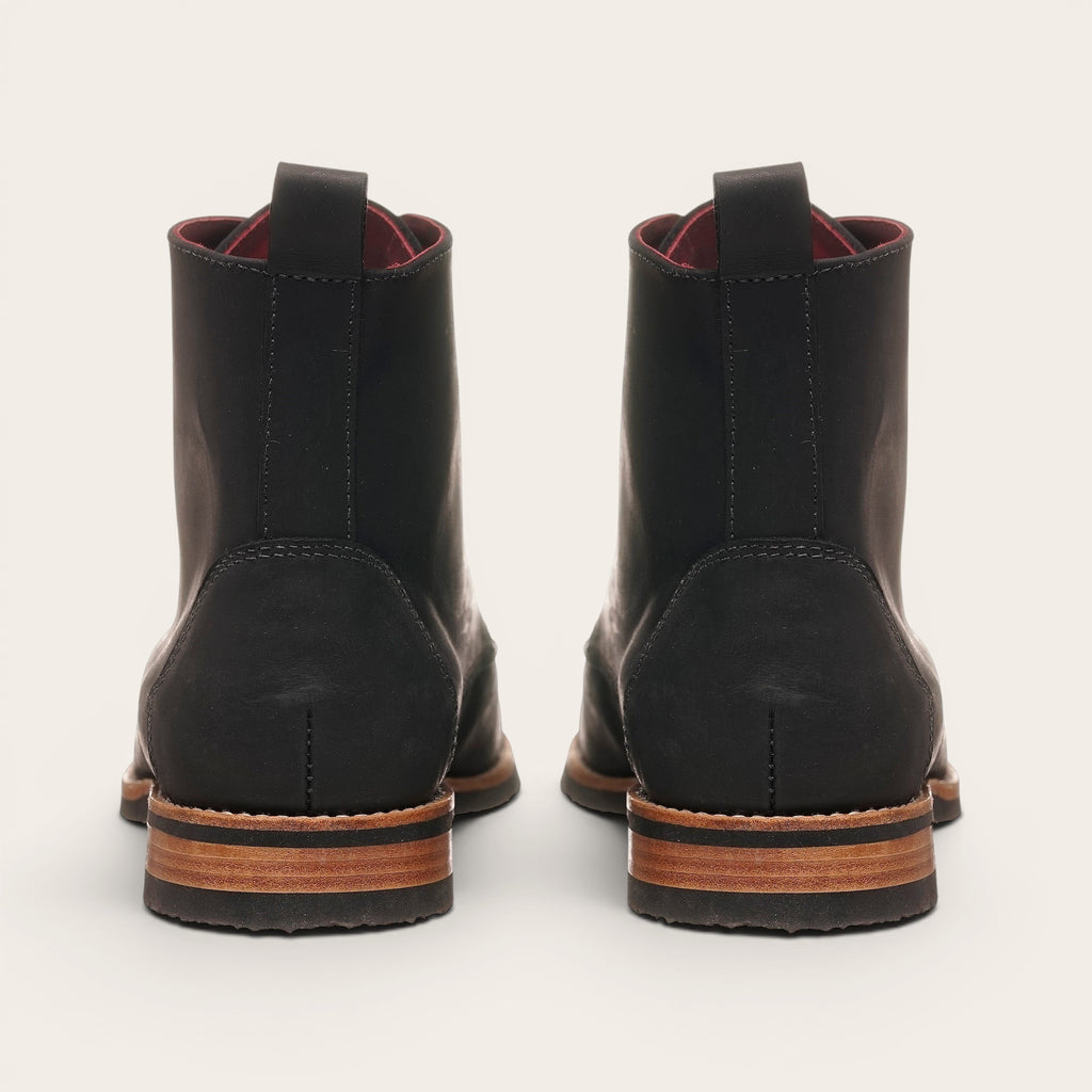 Botín Osorno Negro Planta Negra de cuero para hombre de OLKI. Diseño clásico con tirante trasero y suela de cuero y caucho.