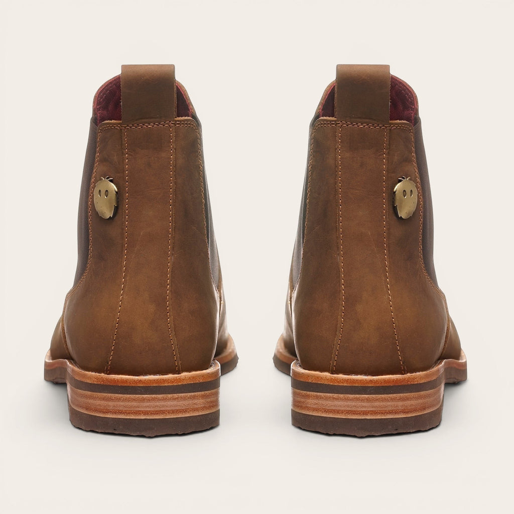 Botín Chelsea de cuero camel para hombre OLKI con suela de goma chocolate y detalle metálico lateral.