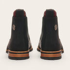 Botines chelsea negros de cuero para hombre OLKI con suela de cuero y caucho, con elásticos laterales. Detalle de pin metálico.