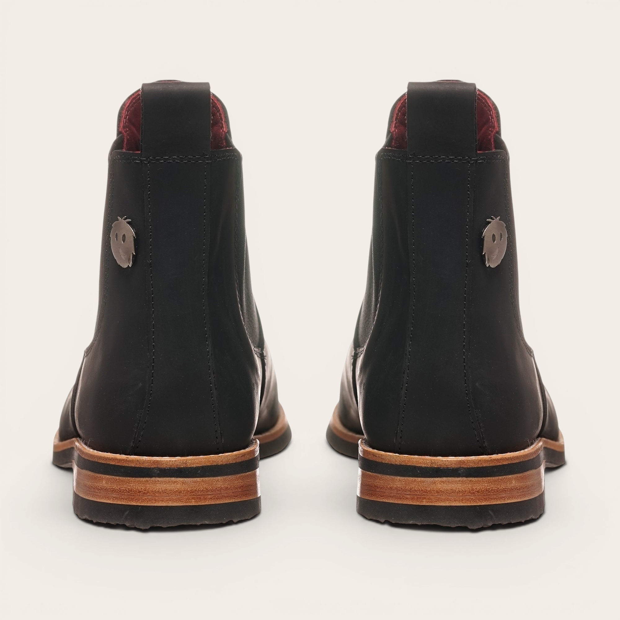 Botines chelsea negros de cuero para hombre OLKI con suela de cuero y caucho, con elásticos laterales. Detalle de pin metálico.