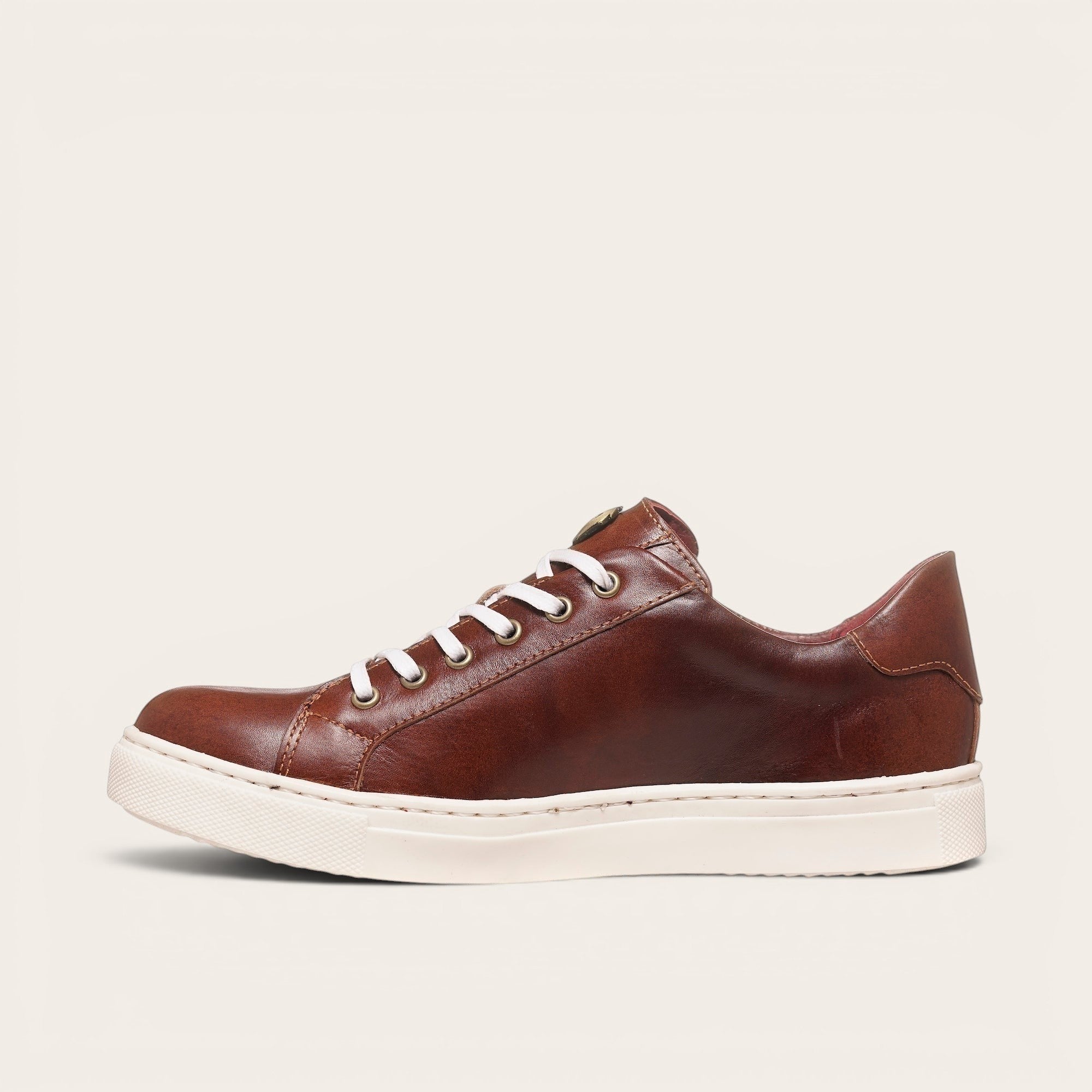 Zapatilla OLKI Tronador de cuero vacuno marrón con cordones blancos y suela de caucho blanca.