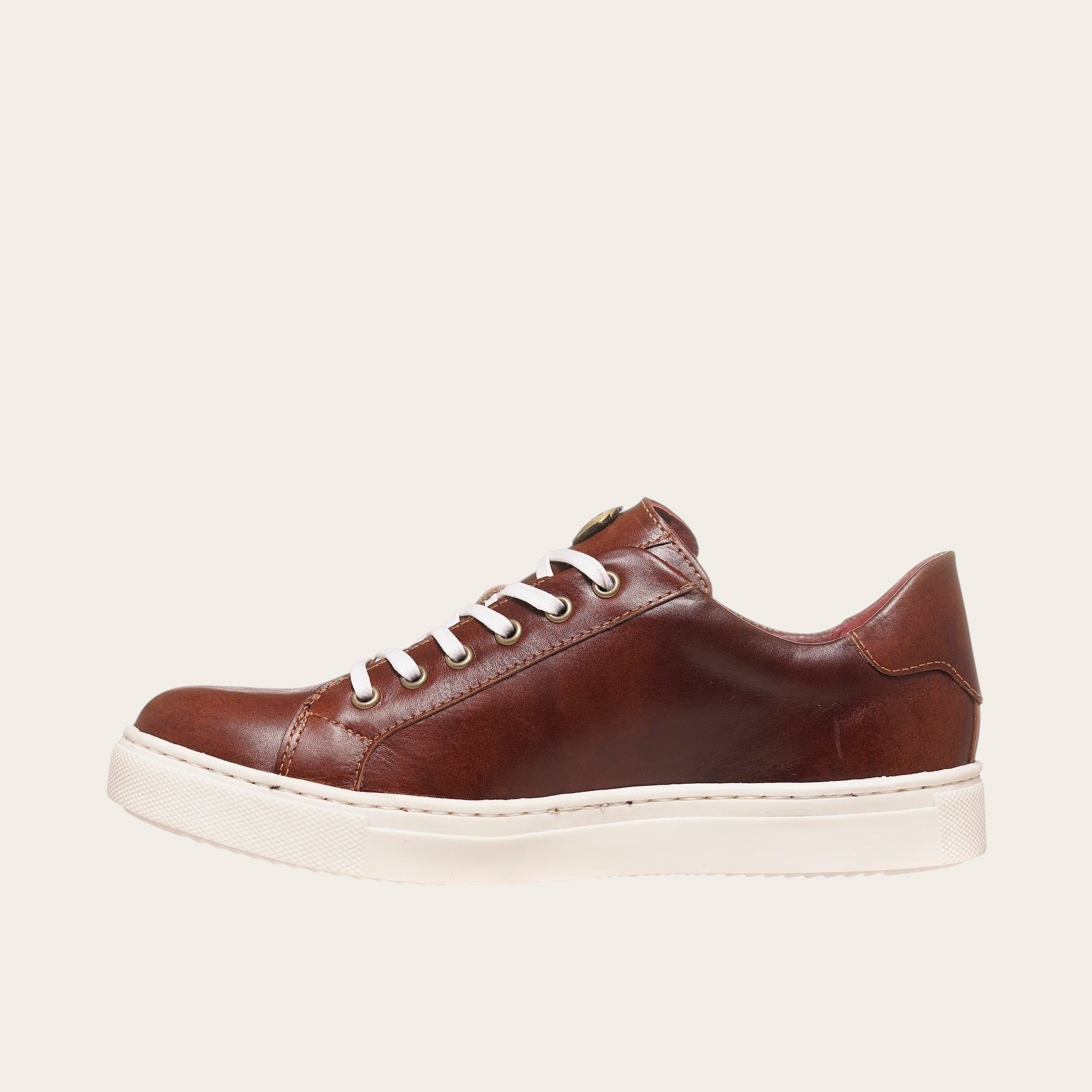 Zapatilla OLKI Tronador de cuero vacuno marrón con cordones blancos y suela de caucho blanca.
