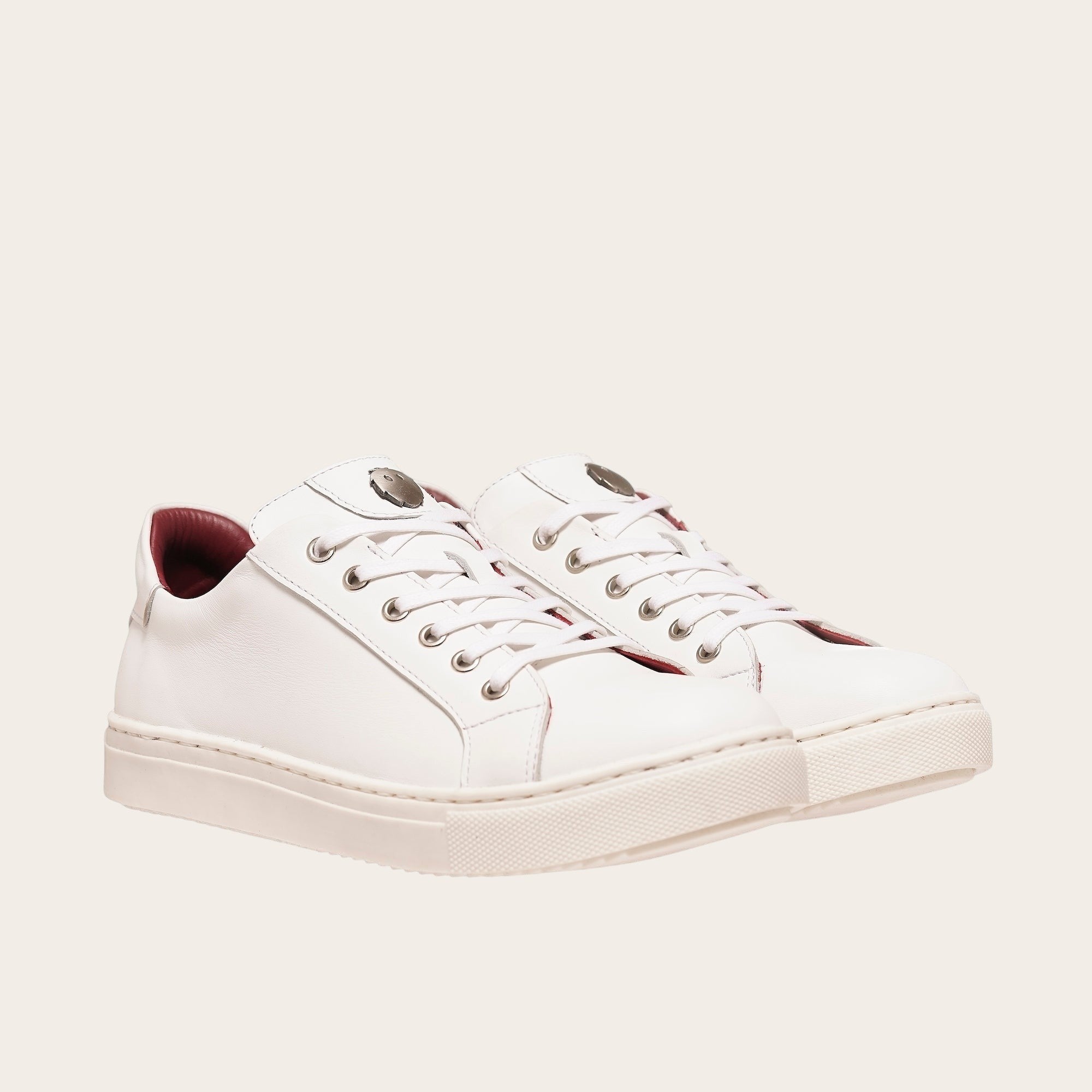 Zapatilla OLKI Tronador blanca de cuero de vacuno con forro guinda y planta de caucho antideslizante. Diseño casual.