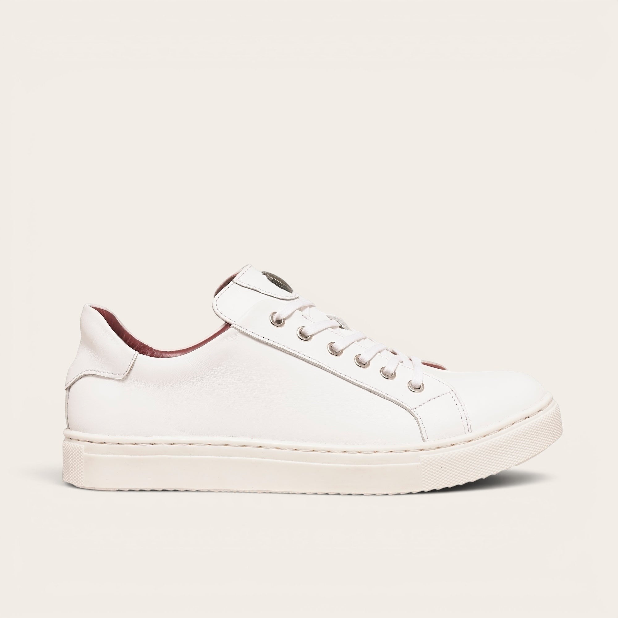 Zapatilla OLKI Tronador blanca de cuero de vacuno con forro guinda y planta de caucho antideslizante. Diseño casual.