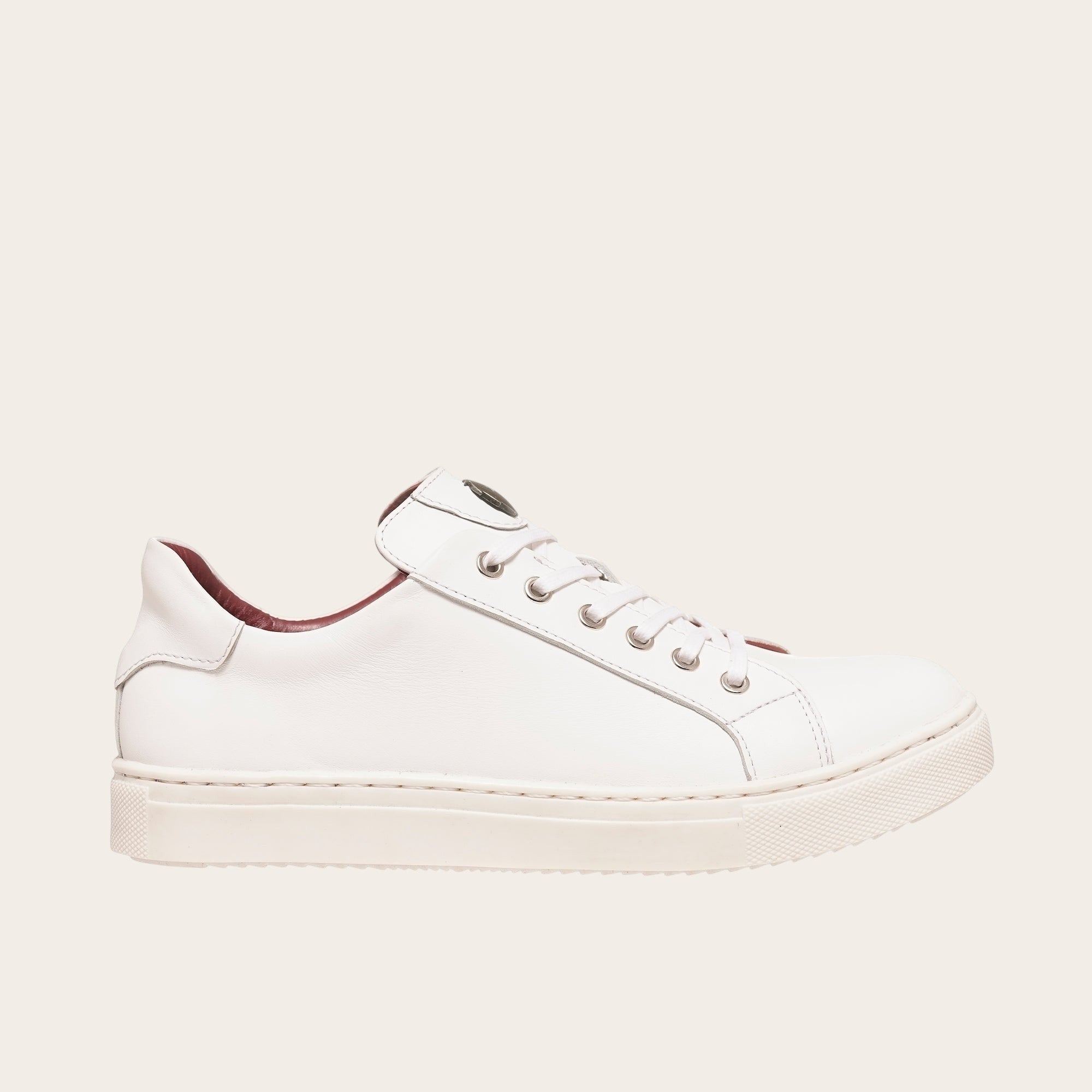 Zapatilla OLKI Tronador blanca de cuero de vacuno con forro guinda y planta de caucho antideslizante. Diseño casual.