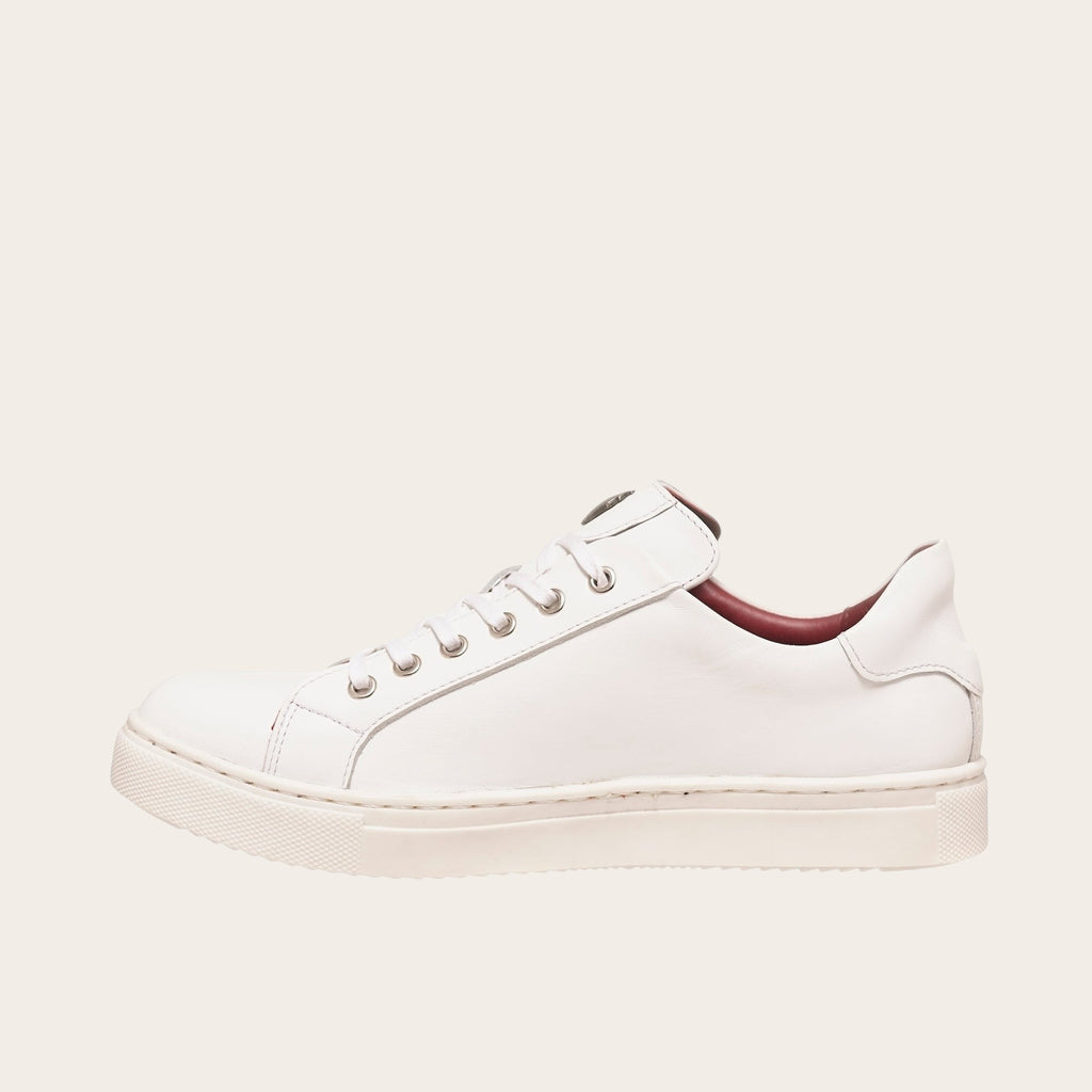 Zapatilla OLKI Tronador blanca de cuero de vacuno con planta de caucho antideslizante y cordones de algodón encerado. Diseño casual.
