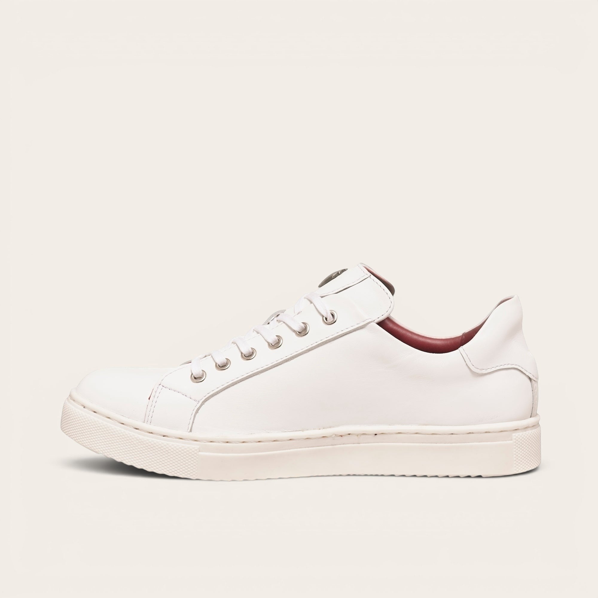 Zapatilla OLKI Tronador blanca de cuero de vacuno con planta de caucho antideslizante y cordones de algodón encerado. Diseño casual.