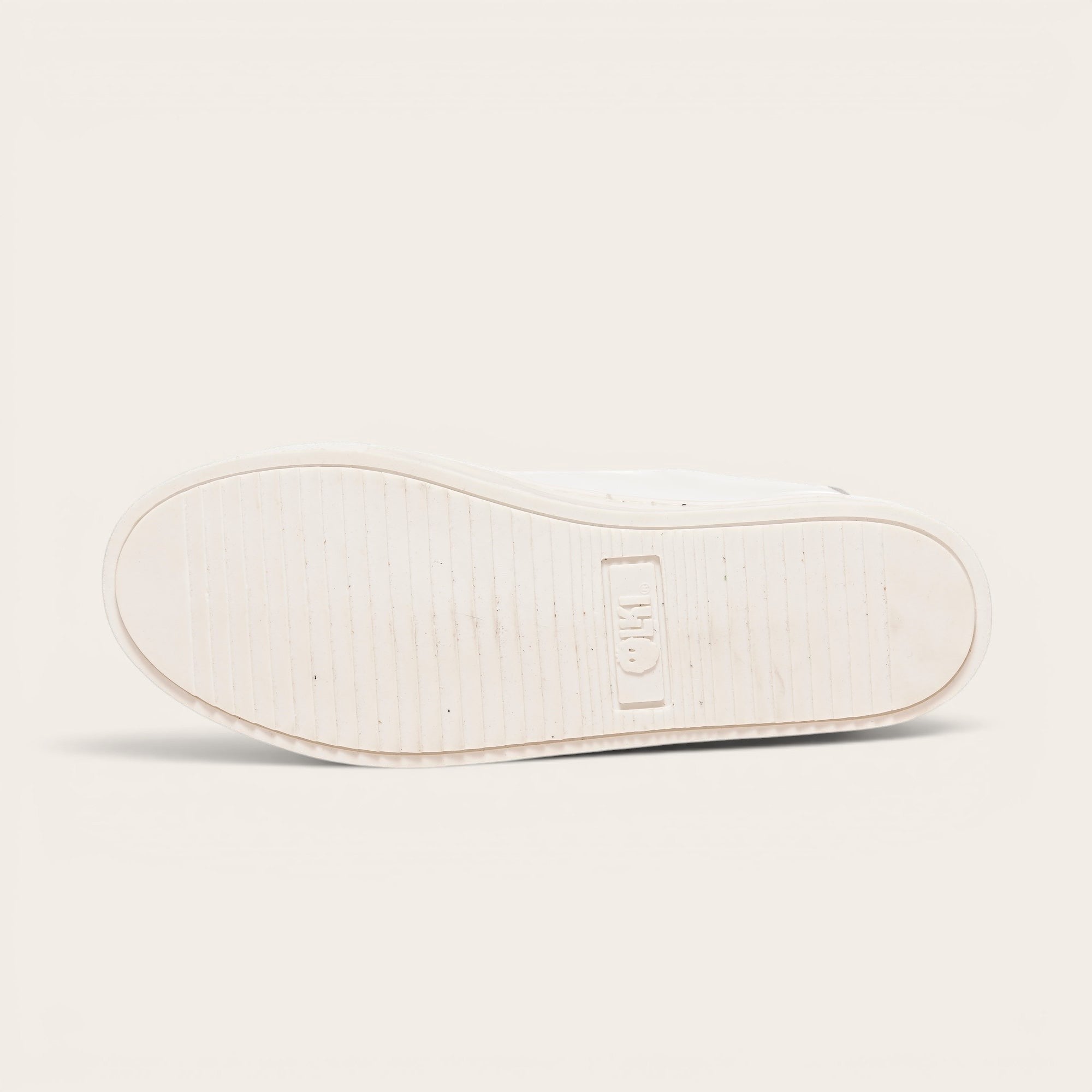 Zapatilla OLKI Tronador blanca de cuero de vacuno con planta de caucho antideslizante y cordones de algodón. Diseño casual.