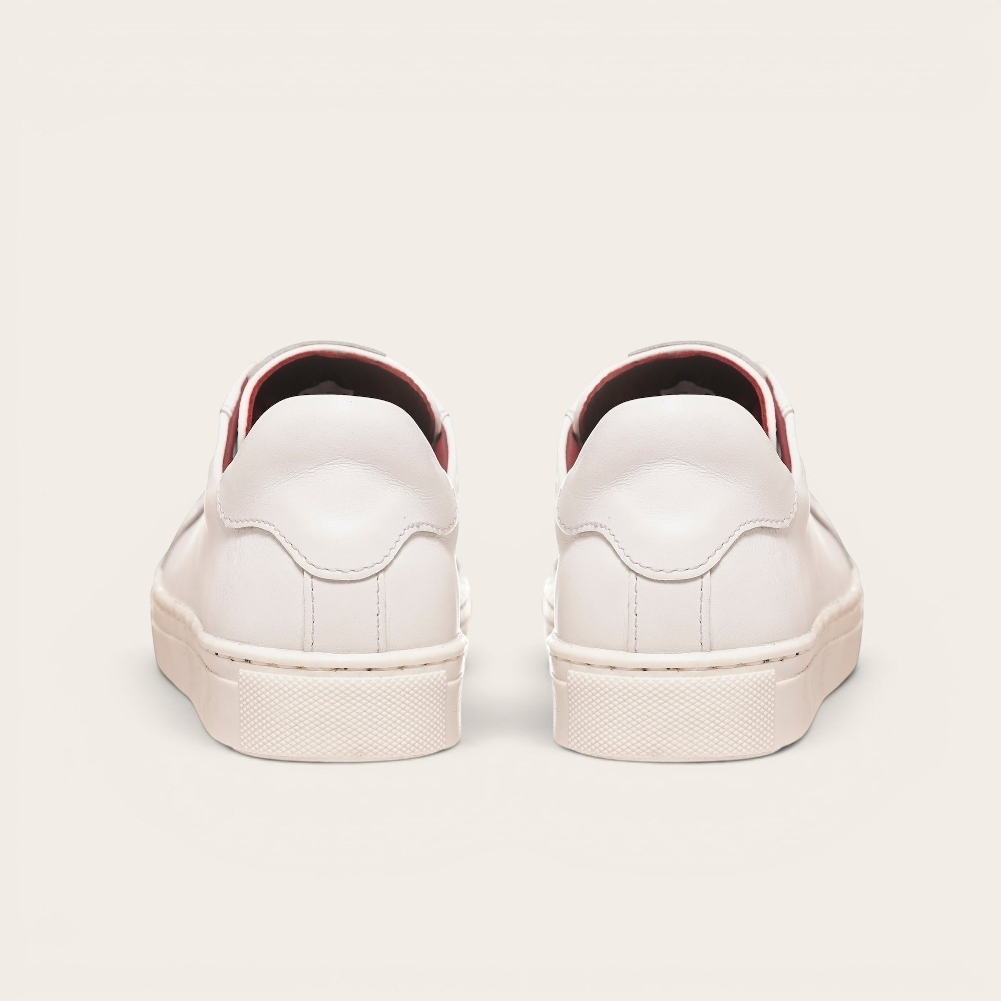 Zapatillas blancas de cuero de vacuno OLKI Tronador con planta de caucho antideslizante y forro guinda. Diseño casual.