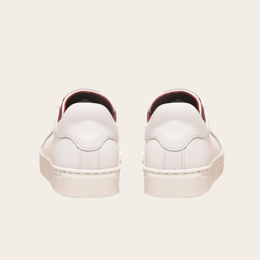 Zapatillas blancas de cuero de vacuno OLKI Tronador con planta de caucho antideslizante y forro guinda. Diseño casual.