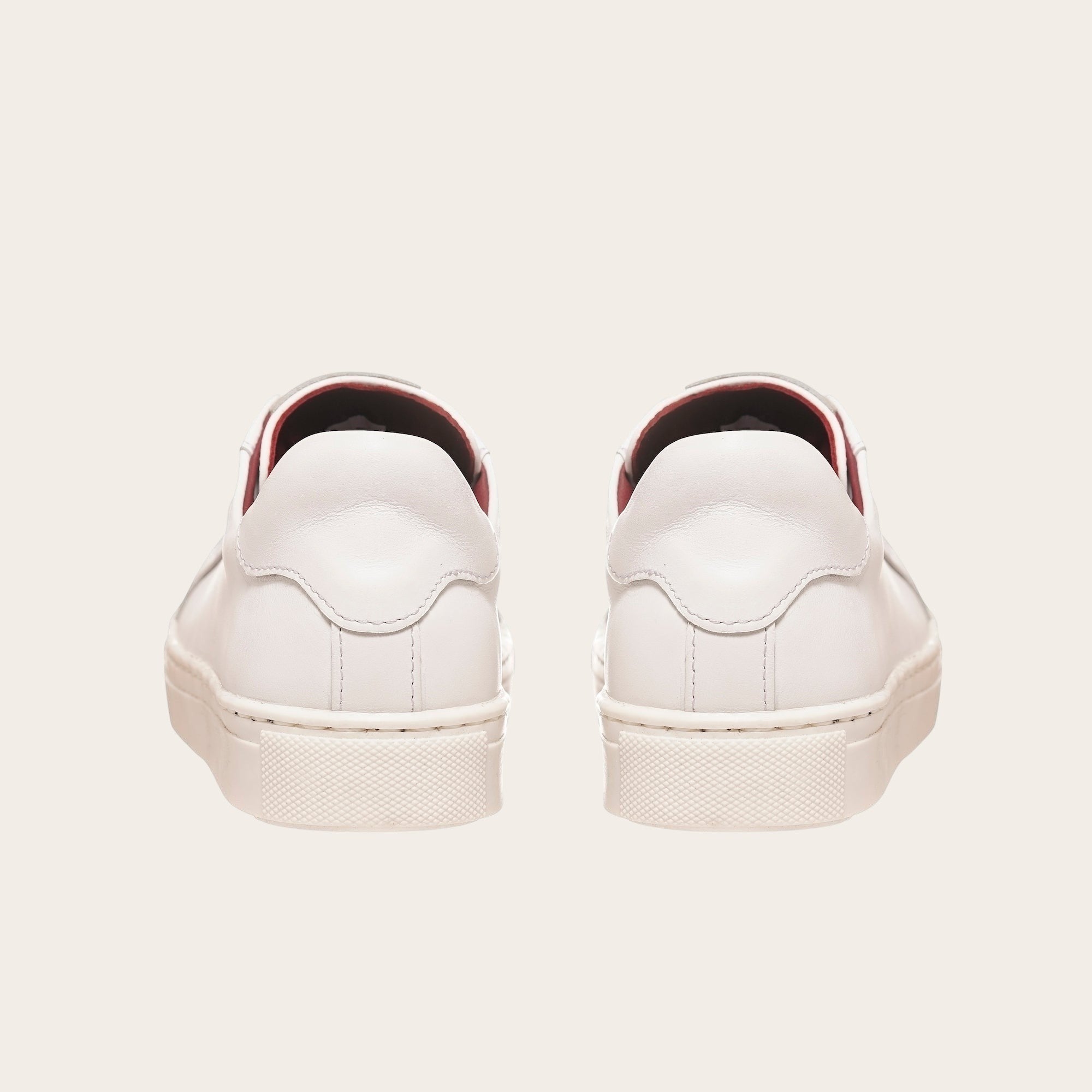 Zapatillas blancas de cuero de vacuno OLKI Tronador con planta de caucho antideslizante y forro guinda. Diseño casual.