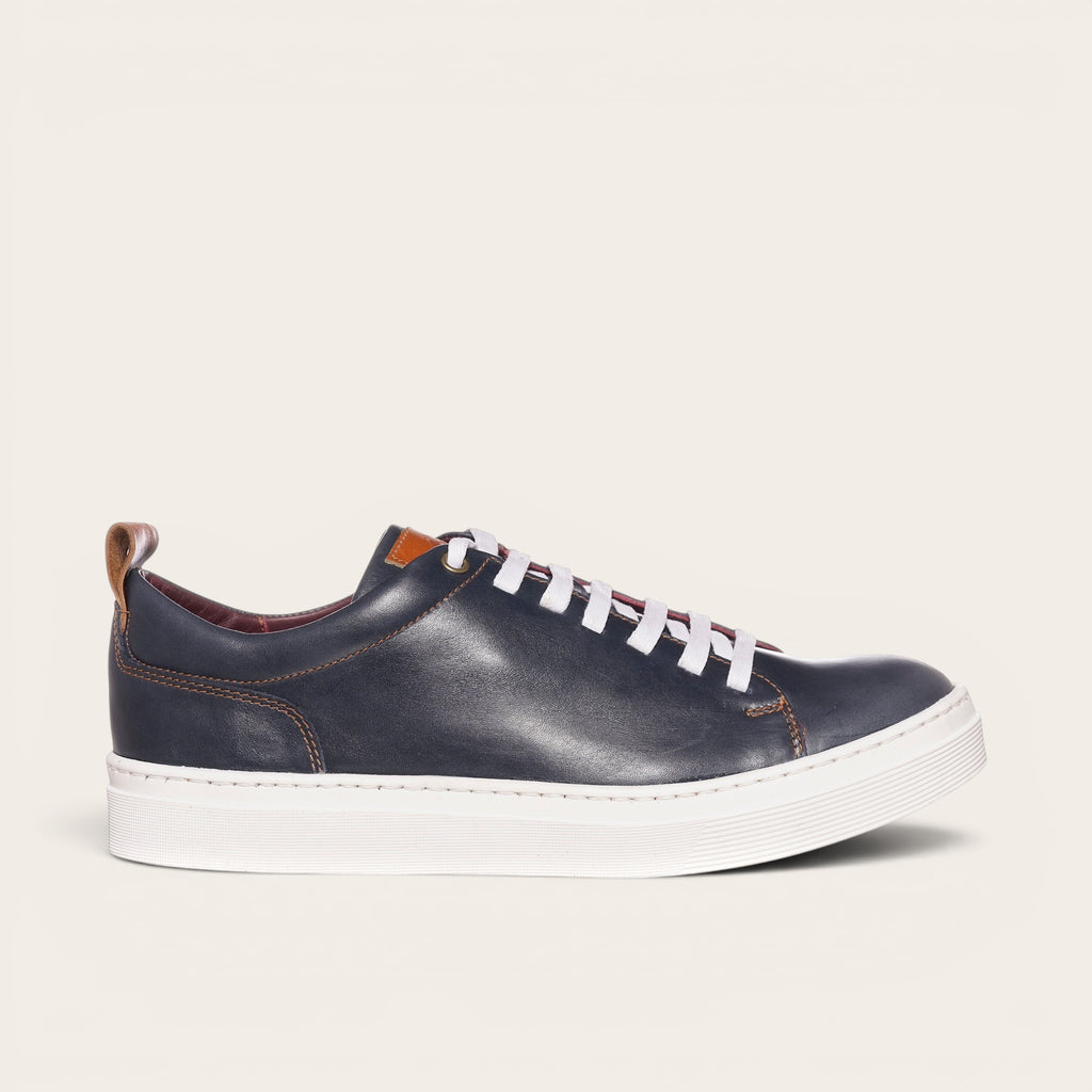 Zapatilla OLKI Calán azul marino de cuero con cordones blancos y planta blanca.