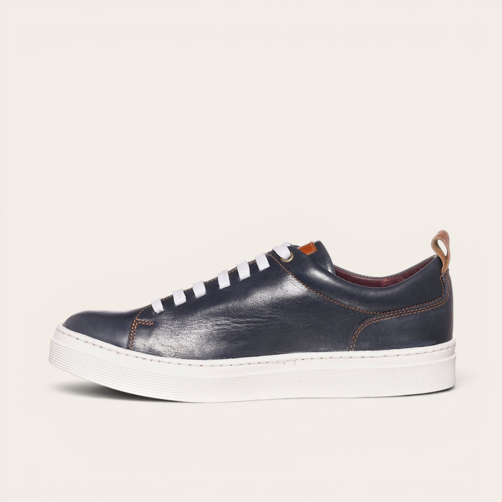 Zapatilla OLKI Calán azul marino de cuero con cordones blancos y planta blanca. Diseño artesanal.