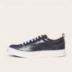 Zapatilla OLKI Calán azul marino de cuero con cordones blancos y planta blanca. Diseño artesanal.