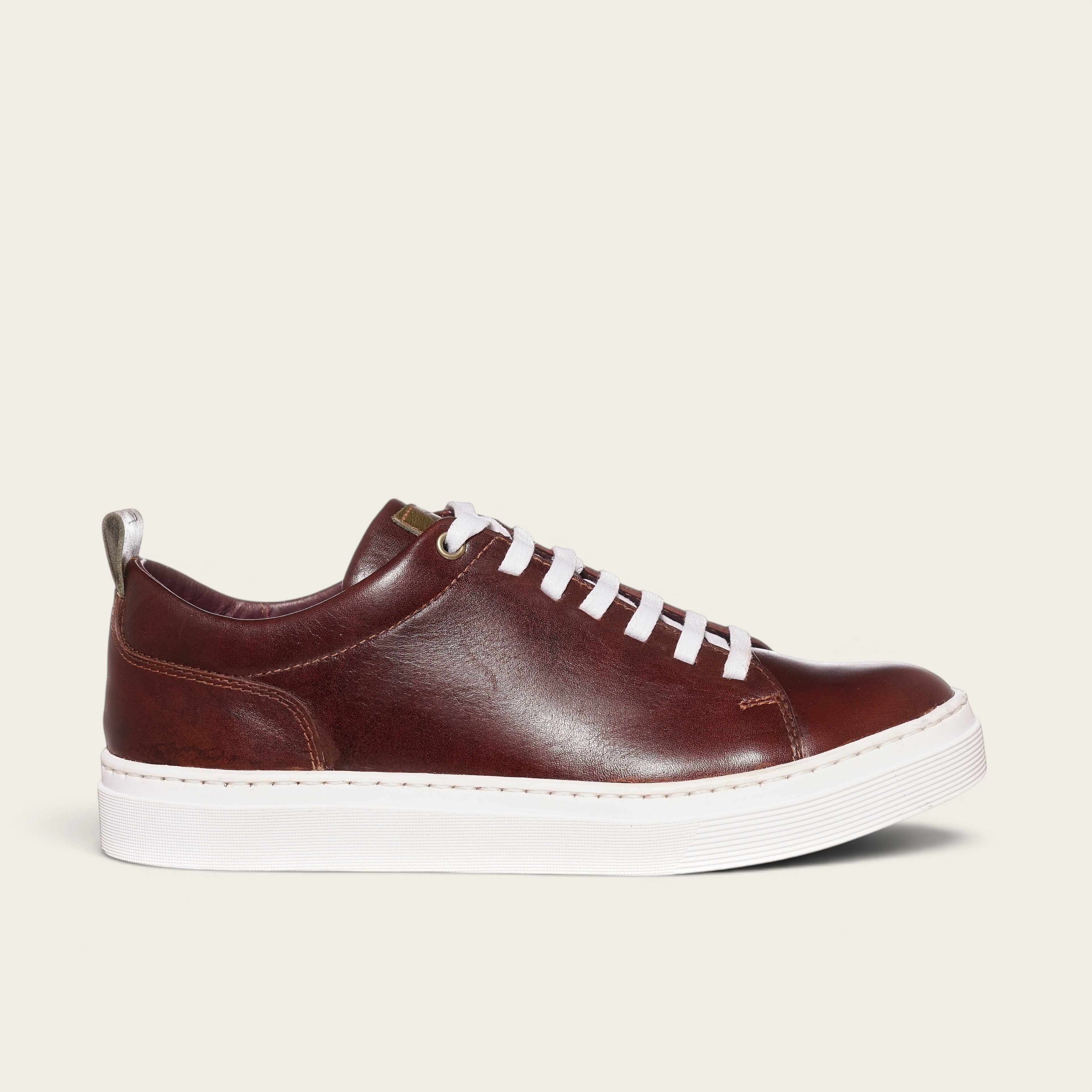 Zapatilla OLKI Calán de cuero castaño con cordones blancos y planta blanca. Diseño artesanal chileno.