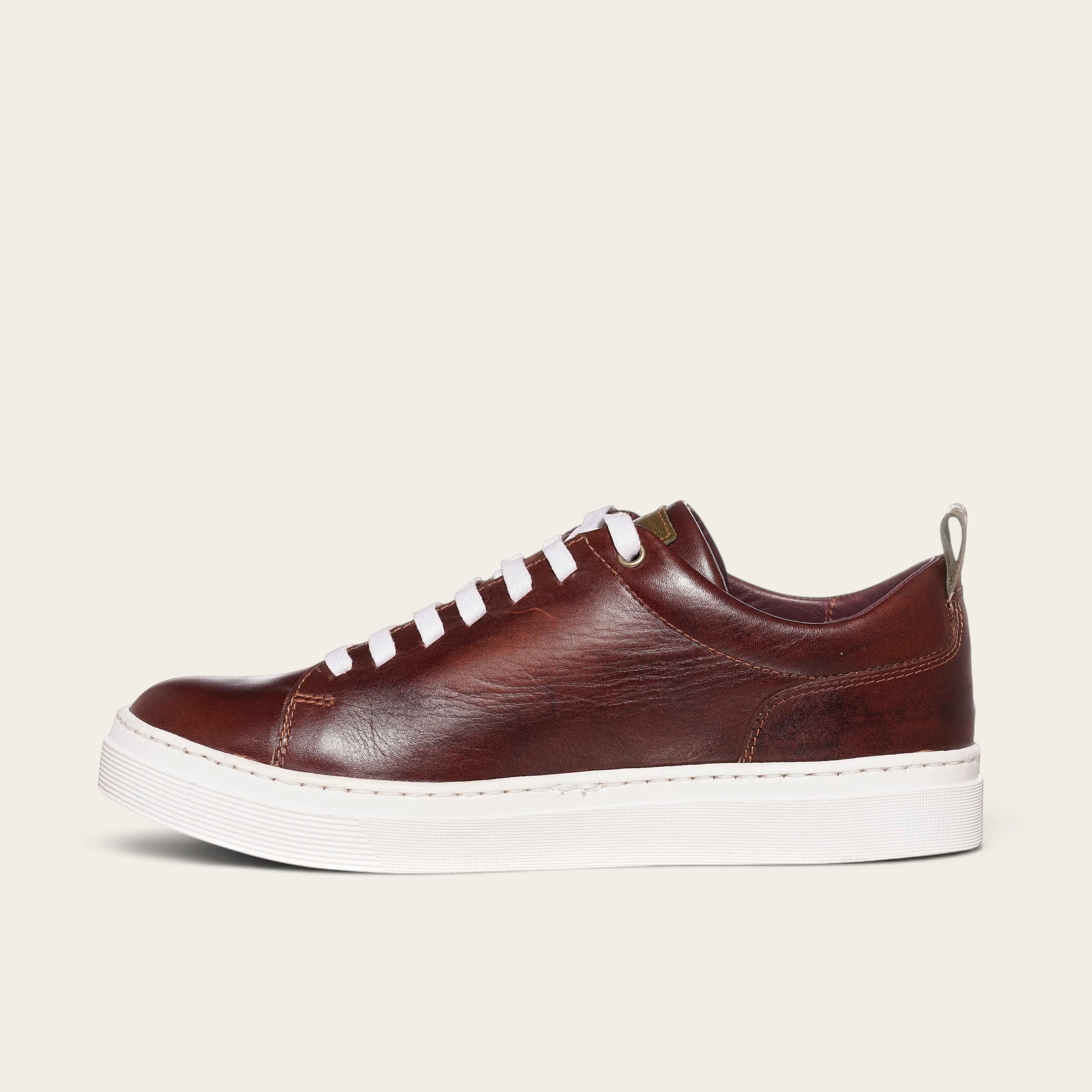 Zapatilla OLKI Calán de cuero castaño con cordones blancos y planta blanca. Diseño artesanal chileno.
