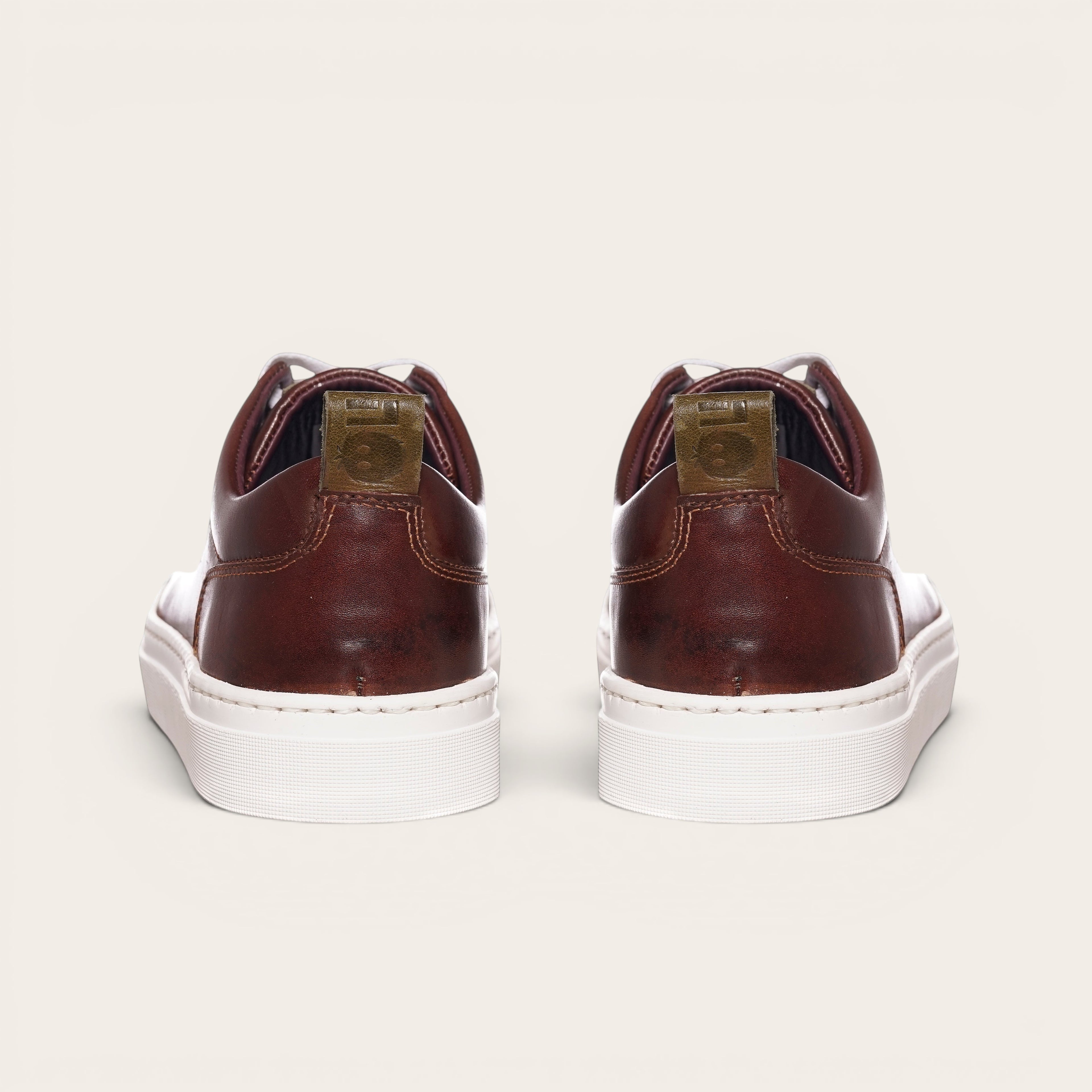 Zapatilla Calán de cuero castaño de OLKI con planta blanca gruesa y detalle de logo en el talón.