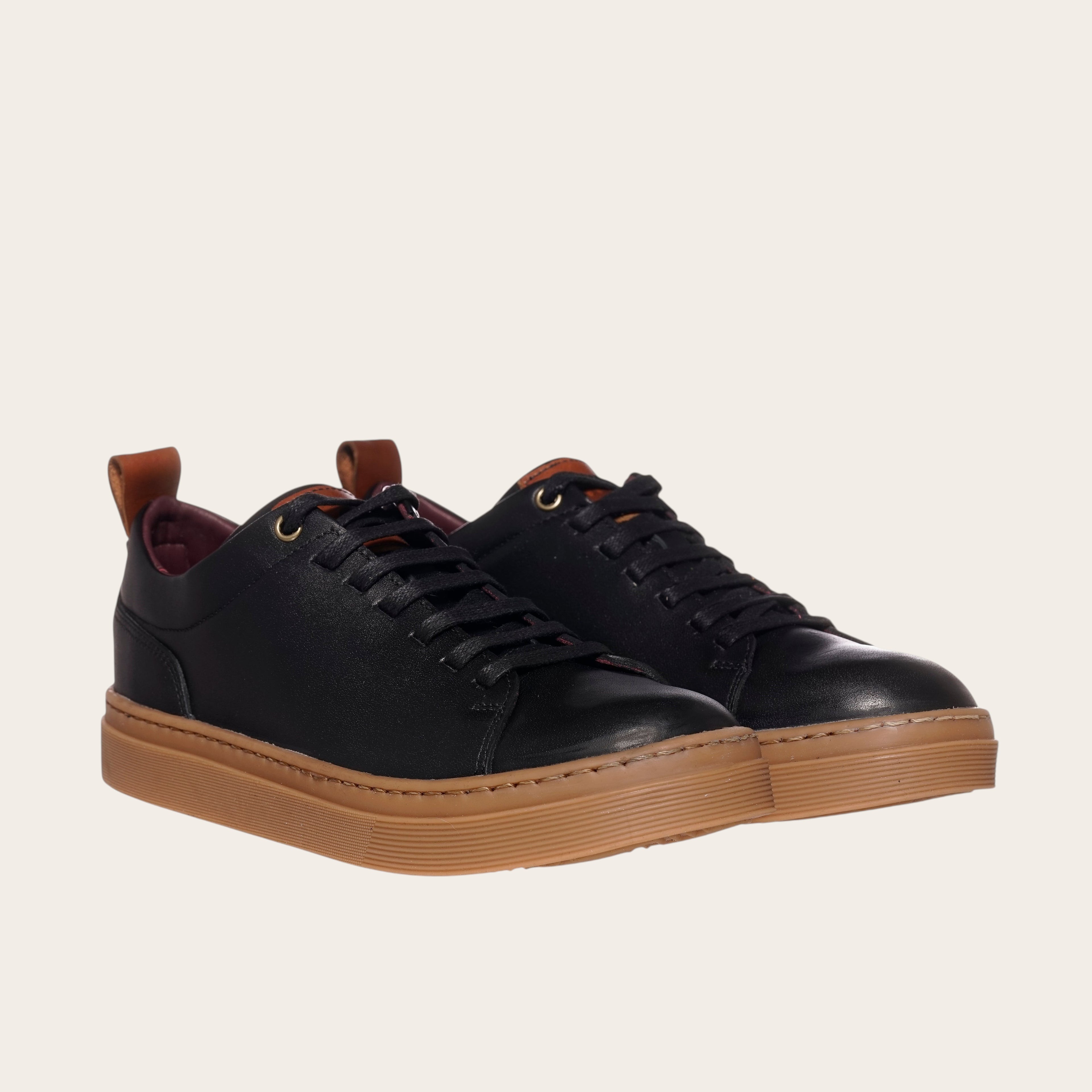 Zapatilla Calán negra de cuero con planta de caucho color cristal y cordones a juego. Diseño minimalista.