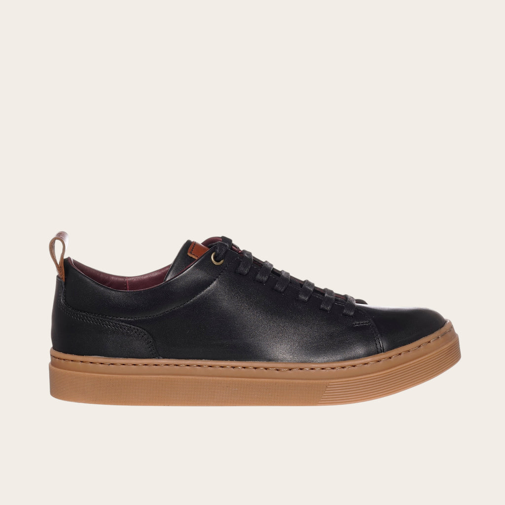 Zapatilla OLKI Calán negra de cuero con planta de planta color cristal y detalles en cuero.