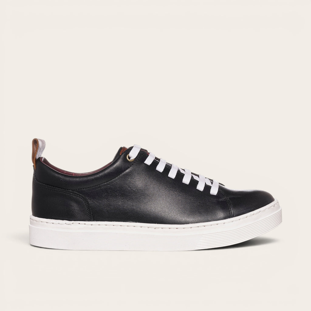Zapatilla OLKI Calán negra de cuero con cordones blancos y planta blanca. Diseño artesanal chileno.
