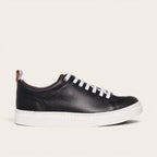 Zapatilla OLKI Calán negra de cuero con cordones blancos y planta blanca. Diseño artesanal chileno.