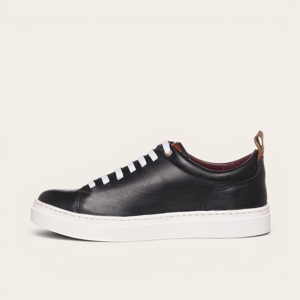 Zapatilla OLKI Calán negra de cuero con cordones blancos y planta blanca. Diseño artesanal chileno.