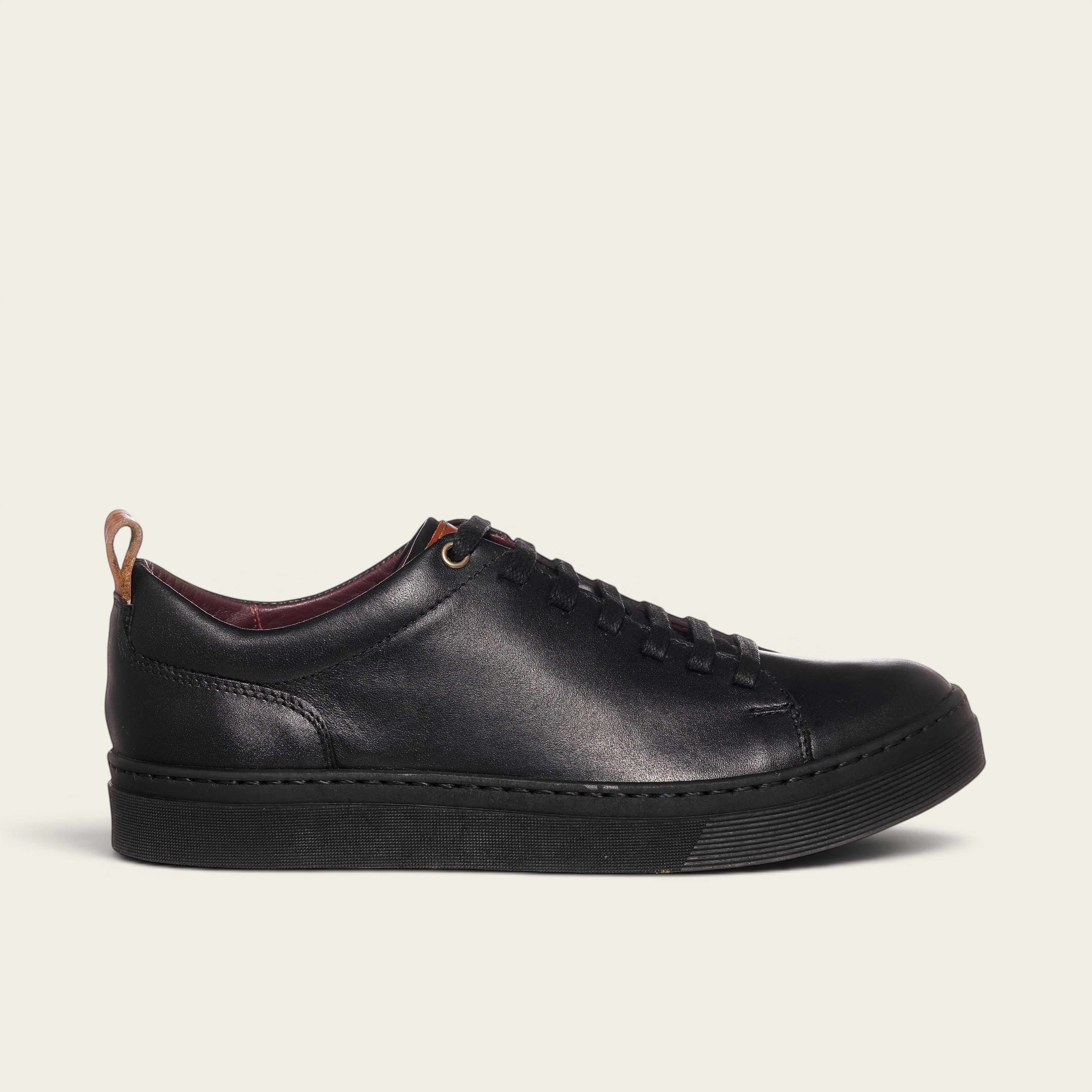 Zapatilla OLKI Calán negra de cuero con cordones y planta negra. Diseño artesanal chileno.