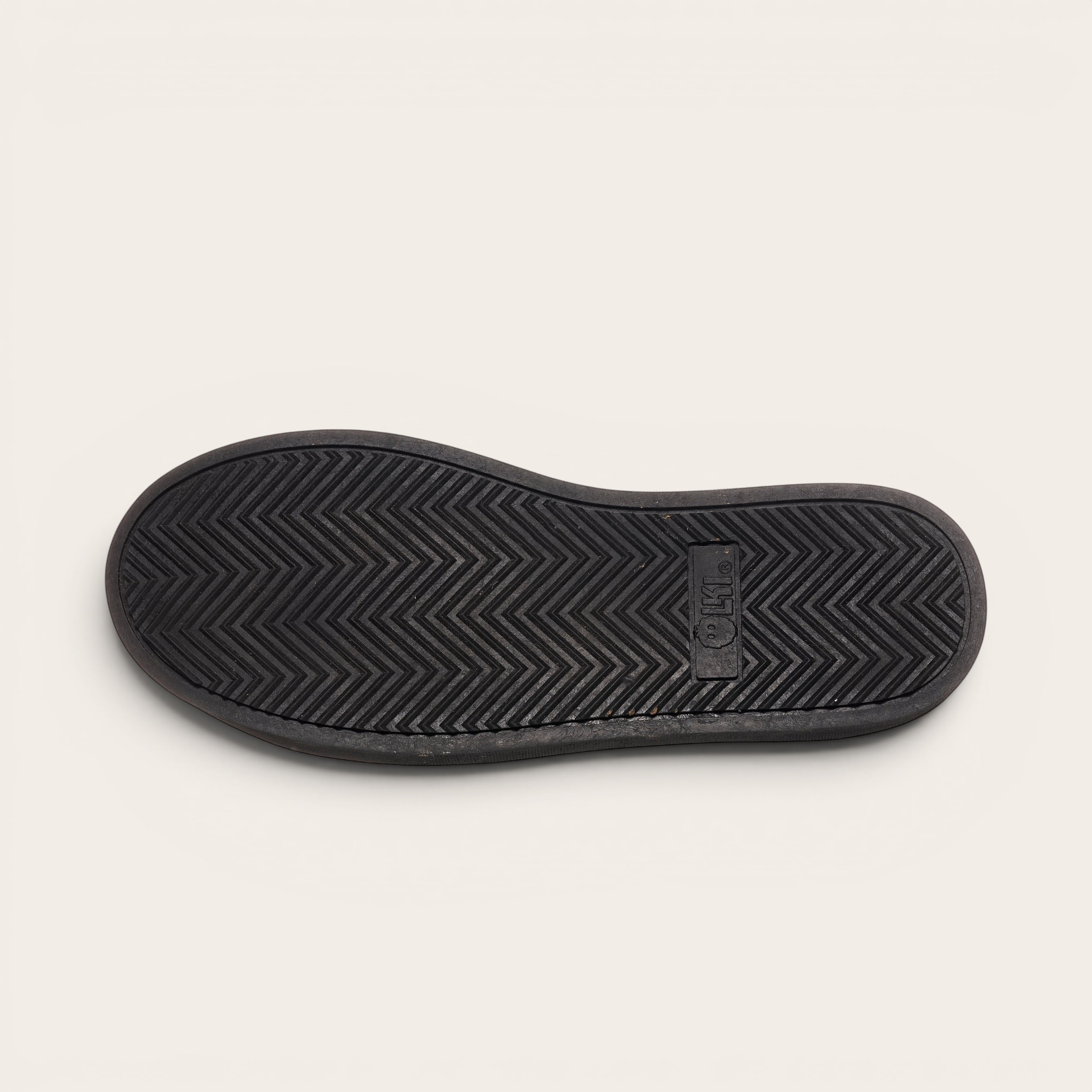 OLKI Zapatilla Calán negra con planta de caucho antideslizante negra y diseño de espiga.