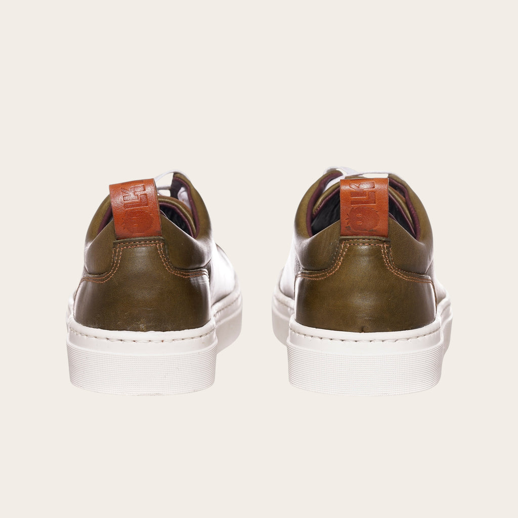 Zapatilla OLKI Calán verde musgo de cuero con planta blanca y detalle de cuero en el talón.